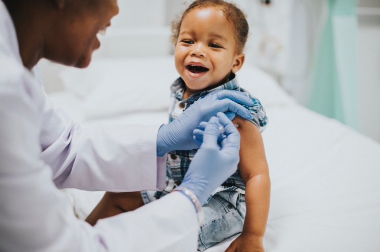 An African male toddler getting a vaccination jab from a male health worker. 