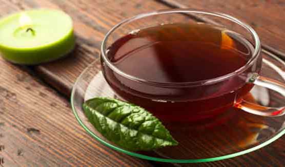 Featured image showing a cup of black tea on a saucer with a slice of lemon beside the on the table